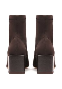 Botas de tobillo de tela marrón con un tacón cuadrado negro y bloque, que presentan costuras elegantes y una silueta ajustada para una apariencia aerodinámica.