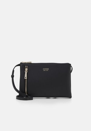Zwarte Guess crossbodytas met gouden ritssluiting en afneembare riem, voorzien van het "GUESS EST 1981" logo aan de voorkant.