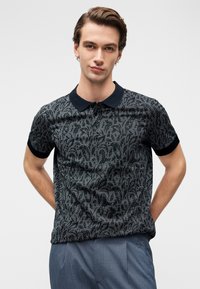 Μπλουζάκι πόλο με κοντά μανίκια σε σκούρο γκρι με μαύρο σχέδιο πασλεΐ, με μαύρο γιακά και υφασμάτινη υφή. Σχεδιασμένο με εφαρμοστή γραμμή.