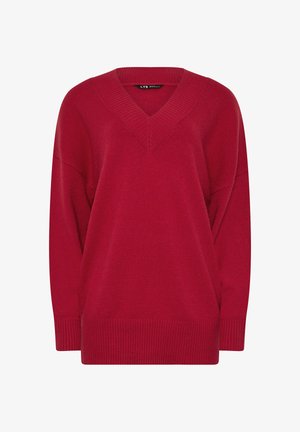 Czerwony sweter z dzianiny z dekoltem w kształcie litery V, opuszczonymi ramionami i prążkowanym wykończeniem. Miękka tekstura, luźny krój i bezszwowa konstrukcja.