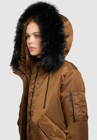 Hnědá saténová parka s černou kapucí z umělé kožešiny, s kapsou na zip na rukávu a stahovacími šňůrkami. Jemná textura a zateplený design.