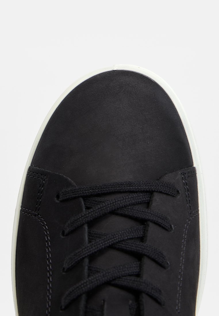 Schwarzer Sneaker mit schwarzen Schnürsenkeln und weißer Sohle, von oben betrachtet, mit Fokus auf der Zehe und einem Teil der Schnürung.