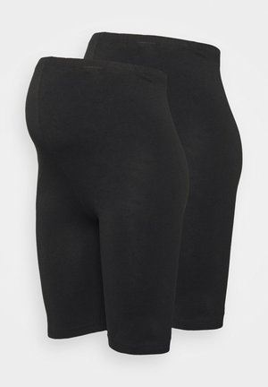 Leggings noirs jusqu'aux genoux en matériau extensible. Dotés d'une texture lisse avec une taille élastique et sans motifs ni accessoires visibles.