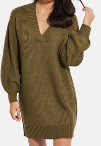 Olivengrünes, gestricktes Sweaterkleid mit V-Ausschnitt, gerippten Bündchen und Saum. Es hat lässige, weit geschnittene Ärmel und eine strukturierte Oberfläche.