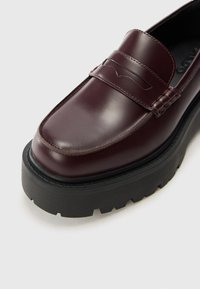 Burgunderfargede skinnloafers med en jevn finish, med en hevet kant og tykk svart gummisåle med et sikksakkmønster for godt grep.
