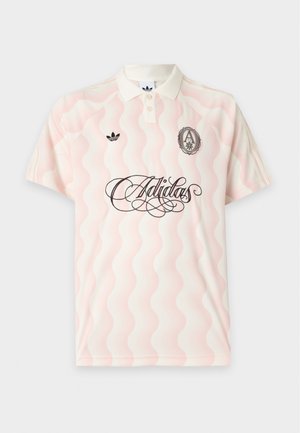 Bladoróżowa i biała falista koszulka polo Adidas z czarnym logo Adidas, szczegółowym herbem oraz dekoracyjnym napisem z przodu.