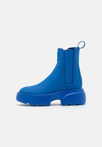 Bottines à plateforme bleu vif avec tirette, panneaux latéraux élastiques et semelle épaisse texturée sur fond blanc.