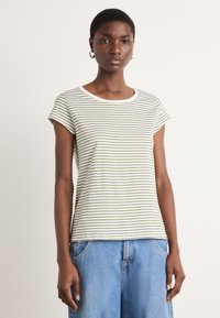T-shirt a righe a maniche corte in crema e verde oliva, con scollo rotondo e texture morbida. Indossato con pantaloncini in denim blu chiaro.