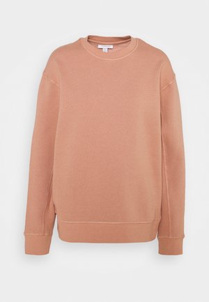 Bluza w kolorze brzoskwiniowym wykonana z miękkiej mieszanki bawełny, z dekoltem typu crew neck, długimi rękawami oraz ściągaczami z widocznymi detalami szwów.