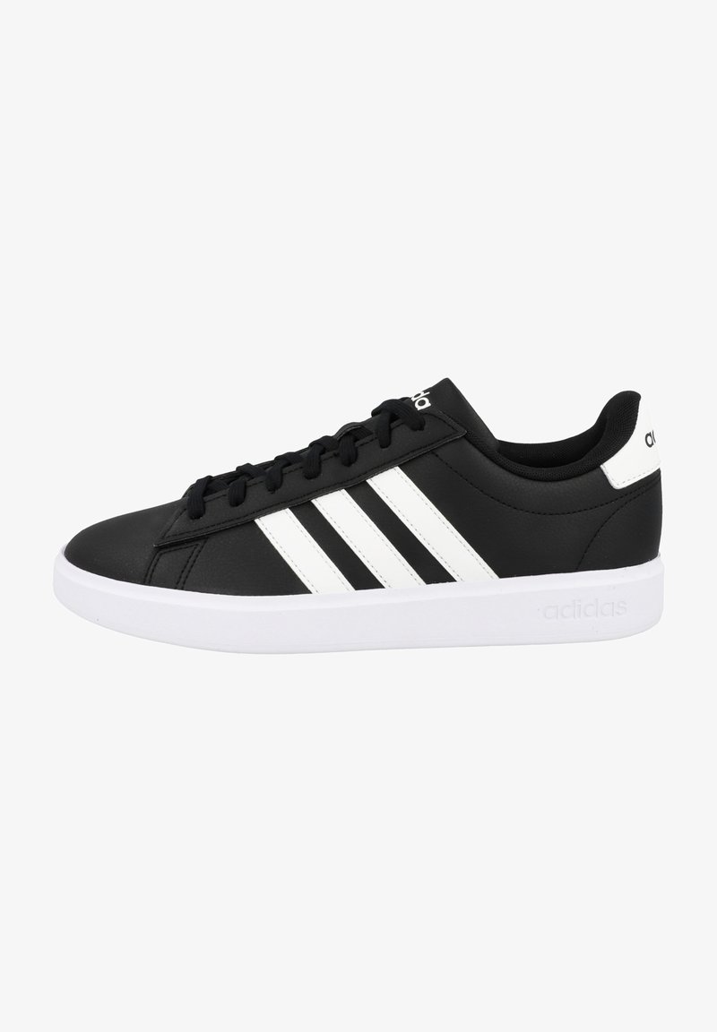 Zwarte sneakers van synthetisch materiaal met een wit ontwerp van drie strepen, een gevoerde kraag en een witte rubberen zool. Logo op de tong en de hiel.