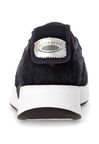 Black suede sneaker with a white cushioned sole. Features a silver logo on the back and textured fabric accents along the sides.