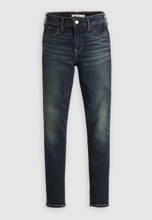 Jean slim bleu foncé avec délavage sur les cuisses et les genoux, design à cinq poches, fermeture par bouton et passants pour ceinture.