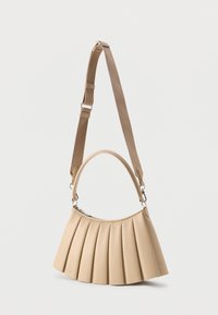 Μπεζ τσάντα με πιέτες, με κυρτή χειρολαβή και ρυθμιζόμενο μπεζ υφασμάτινο ιμάντα ώμου, σε απλό λευκό φόντο.