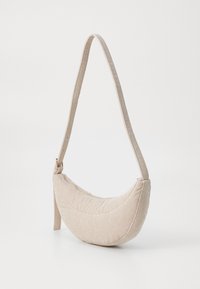 Borsa a spalla in tessuto beige con texture a righe, forma a mezzaluna e una singola tracolla regolabile. Presenta hardware minimale e contorni morbidi.