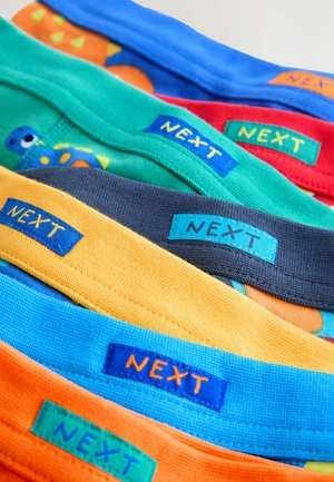Colorful cotton children's briefs with elastic bands labeled "NEXT" in various colors: blue, green, red, gray, yellow, and orange.
