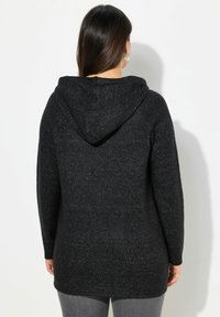 Zwarte hoodie met een gestructureerd breiontwerp; lange mouwen, een verlengde achterkant en subtiele glansdetails in de stof.