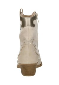 Beige enkelboot van gestructureerd leer, met metallic accenten, gestoken details en een lage hak. Ritsluiting aan de achterkant.