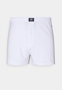 Witte katoenen boxershorts met een elastische tailleband, sluiting met een knop aan de voorkant, en een klein merklabel aan de bovenkant in het midden.