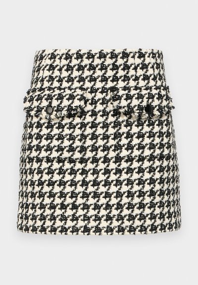 Μαύρη και λευκή φούστα με σχέδιο καρό σε υφή, διαθέτει δύο μπροστινές τσέπες με φθαρμένες άκρες και μαύρες λεπτομέρειες κουμπιού.