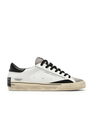 Sneaker basse bianche con lacci neri, linguetta nera sul tallone, suola beige consumata, punta grigia e testo "DISTRESSED WITH NO STRESS" sul lato.