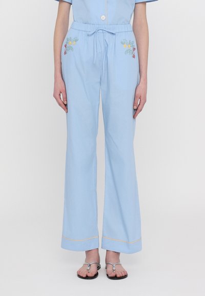 Lichtblauwe, wijde broek met een elastische tailleband. Beschikt over bloemenborduurwerk aan beide zijkanten en een contrasterende bies aan de onderrand.