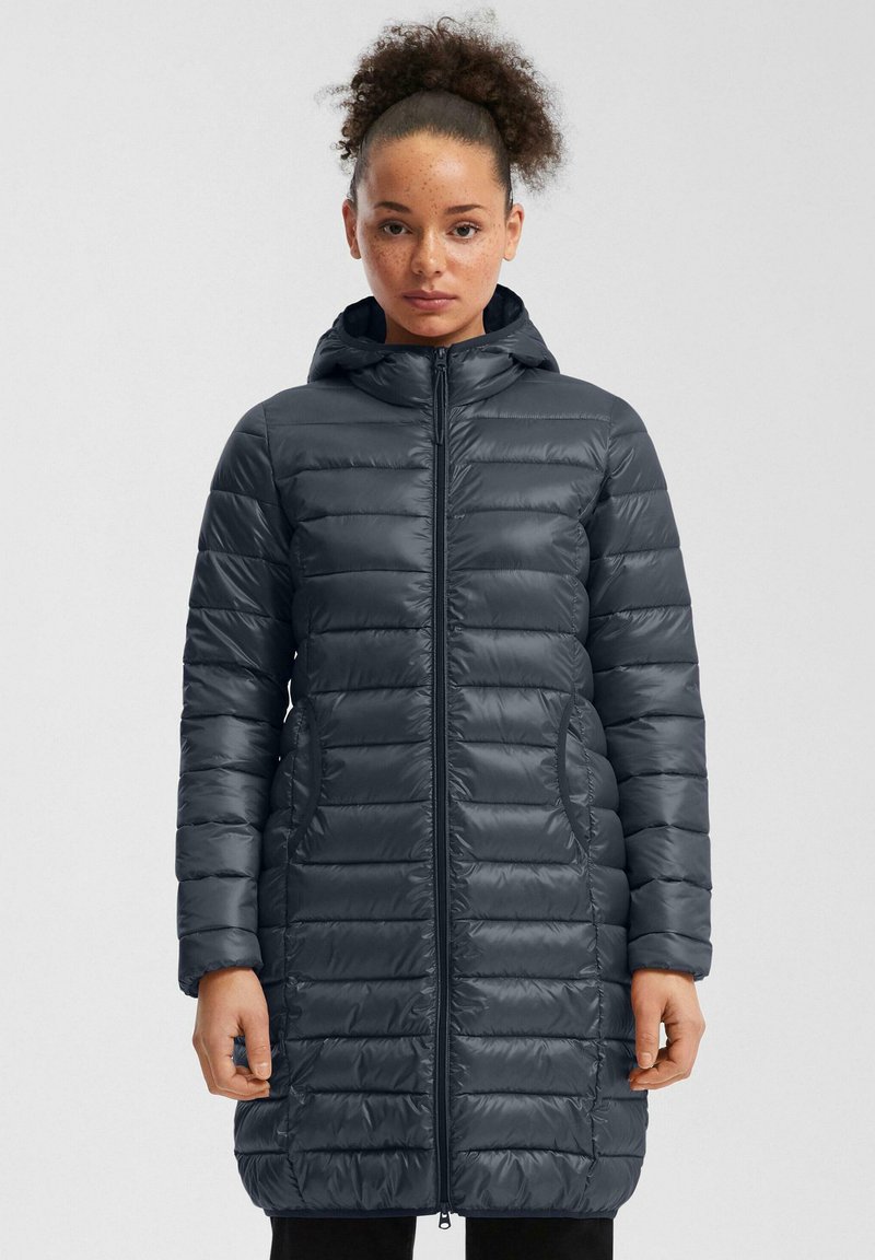 Dug ravan kaput u tamnosivoj boji s kapuljačom, s prednjim zatvaračem, bočnim džepovima i glatkom, sjajnom teksturom. Horizontalni kviltani uzorak.