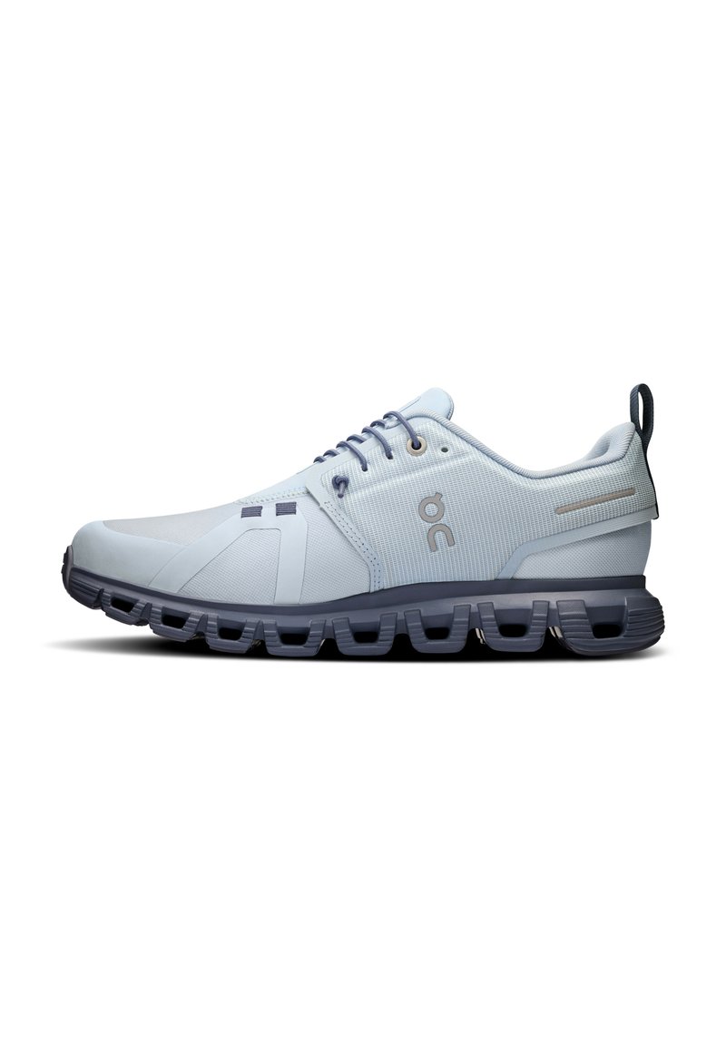 Light blue athletic shoe with a textured upper, contrasting dark sole, lace-up design, and logo accent on the side.