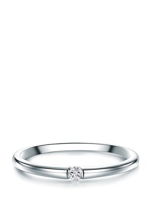 Silberner Bandring mit einem kleinen runden Diamanten, der mittig auf weißem Hintergrund eingefasst ist.