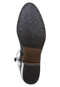Bota de cuero negro con una suela texturizada, punta redondeada, cremallera lateral y logo estampado en el talón. La suela presenta un diseño con patrón.