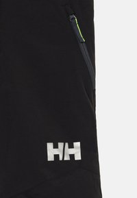 Svart tyg med en vertikal dragkedjeficka som har en neongrön dragflik och en reflekterande vit "HH"-logotyp nära botten.