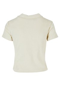 Chemise courte beige à manches courtes en tissu texturé doux avec un col simple, vue de dos.
