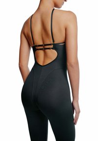 Svart bodysuit med ett utskuret bakdesign, justerbara tunna axelband och metallhardware-accenter. Tillverkad av ett smidigt, töjbart material.