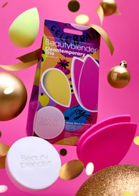 Opakowanie Beautyblender Cleantemporary Trio zawiera trzy gąbki (różową, żółtą i fioletową) oraz biały środek czyszczący na różowym tle.