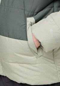 Giubbotto imbottito con design a blocchi di colore verde e grigio chiaro, tessuto testurizzato e tasca visibile con dettagli del logo sul maniche.