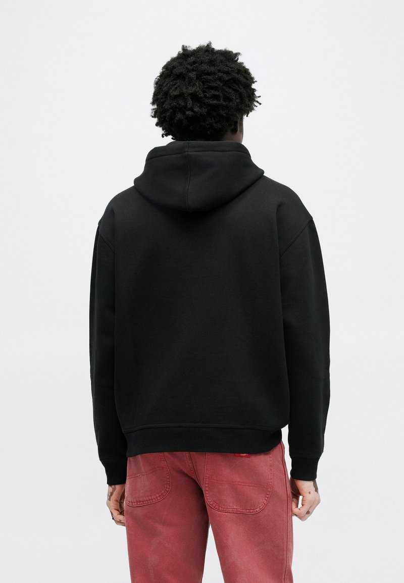 Black hooded sweatshirt with a relaxed fit, made from soft fabric. Features ribbed cuffs and hem, shown from the back with no visible logo.