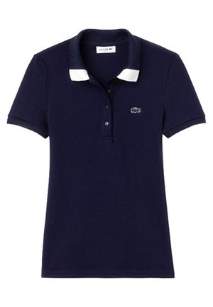 Laivastonsininen lyhythihainen poolopaita, jossa valkoiset kauluksen kärjet, nappilista ja pieni krokotiililogolla vasemmassa rinnassa.