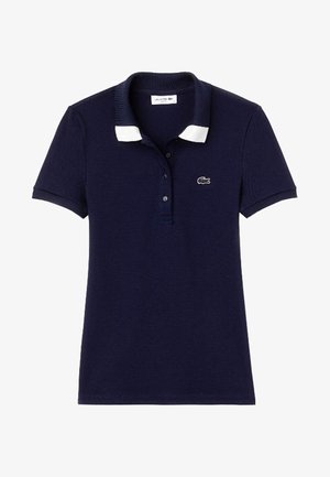 Polo bleu marine à manches courtes avec pointes de col blanches, patte de boutonnage et petit logo crocodile sur la poitrine gauche.