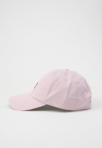 Pink baseball cap with curved brim, made of cotton. Features embroidered accents on the front and eyelets for ventilation.