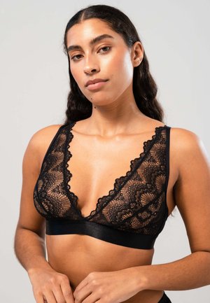 Schwarzes Spitzen-Bralette mit tiefem V-Ausschnitt, gewellten Kanten und einem glatten Satinband am Unterrand. Aufwendiges florales Spitzenmuster sichtbar.