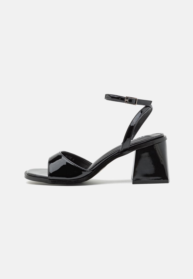 Sandale à talon en cuir verni noir avec un bout carré, un talon bloc, une bride avant ouverte et une bride de cheville avec une petite boucle.