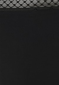 Black stretchy fabric with a ribbed texture, featuring a patterned waistband in gray and white geometric designs.