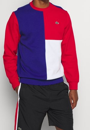Bluza kolorowa z panelami w kolorach czerwonym, białym i niebieskim; ściągacze na rękawach; okrągły dekolt; małe logo na lewej piersi; teksturowany materiał.