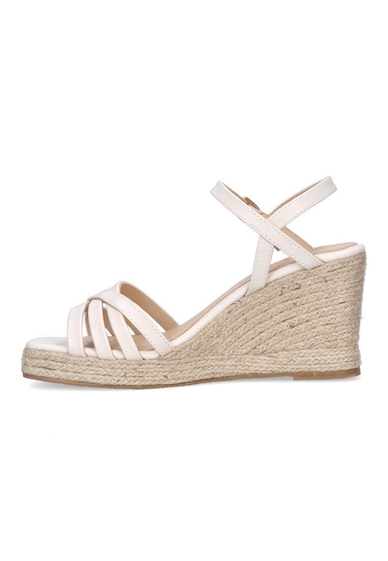 Sandalias de cuña blancas con tiras cruzadas y una plataforma de yute texturizada. El diseño presenta material sintético suave y un talón cerrado.