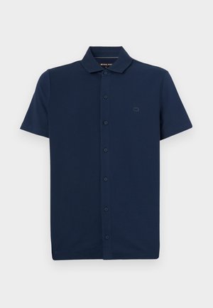 Navy blue short-sleeve polo shirt made of cotton, featuring a button placket, a collar, and a small logo on the left chest. Soft texture.