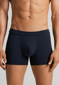 Bóxer azul marino con una tela suave, cinturilla elástica y una bolsa contorneada. Diseñado para la comodidad con una textura suave.