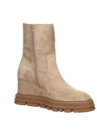 Bottine en daim beige avec fermeture éclair latérale, semelle en caoutchouc marron épaisse et détails cousus, positionnée face à droite.