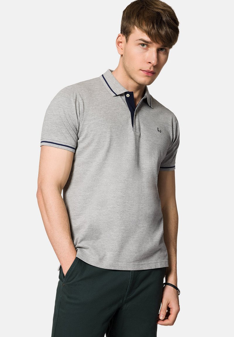 Szara koszulka polo z miękkiego, teksturowanego materiału, z granatowymi akcentami na kołnierzyku i mankietach, z dwoma guzikami przy pliskie i subtelnym logo.
