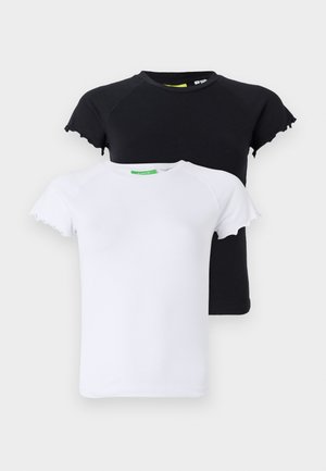 Czarny dopasowany t-shirt, jasnoniebieskie dżinsowe szorty bermudy z brązowym skórzanym paskiem z okrągłymi akcentami oraz czarne kowbojskie buty za kolano z białym stichingiem.