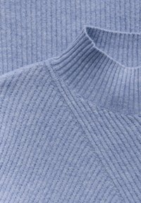 Pull en maille côtelée bleu clair avec un col haut et un motif texturé, comprenant des coutures diagonales et un tissu doux et confortable.