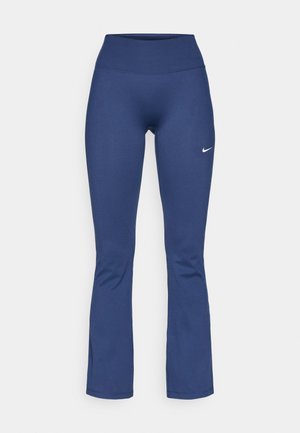 Jūras zila sporta legingi ar augstu jostasvietu, izplešamām kāju atverēm un mazu baltu logotipu kreisajā augšstilbā. Gluda, elastīga auduma.